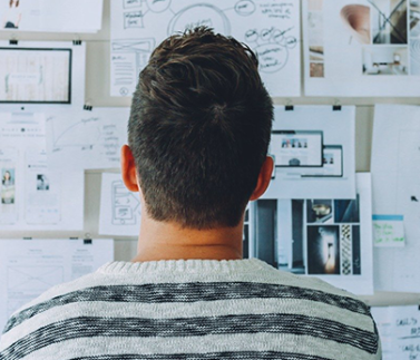 Professionista visualizza bozze e progetti su parete per analisi lavoro