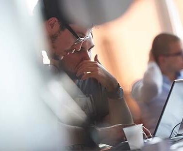 Professionista legale in riunione di lavoro con colleghi e laptop per consulenza fiscale