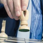 Mano che muove pedina di cavallo su scacchiera in contesto strategico legale