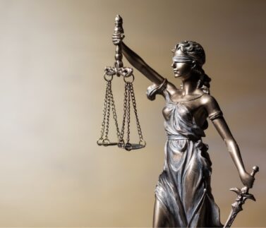 Statua della Giustizia con bilancia e spada, simbolo di legalità e diritto costituzionale