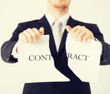 Uomo d'affari in abito nero strappa contratto in due pezzi, rappresentando risoluzione e rescissione contrattuale