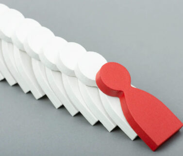 Figura stilizzata rossa che si distingue tra figure bianche, rappresenta licenziamenti collettivi e criteri di scelta s…