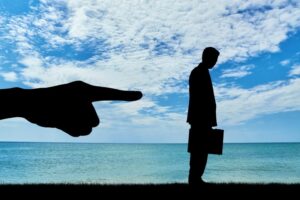 Silhouette uomo d'affari allontanato dal lavoro, mobbing e discriminazione sul lavoro, danno professionale