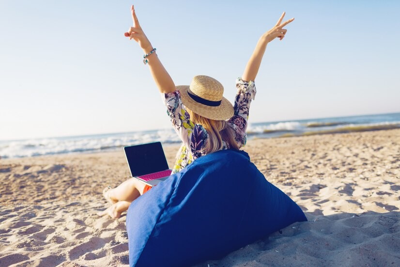 beautiful-young-woman-working-with-laptop-tropical-beach_273443-2279