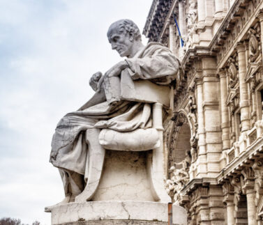 Statua allegorica della Giustizia su edificio storico, simbolo del diritto del lavoro e della tutela legale