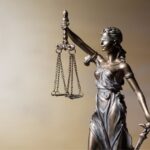 Statua della Giustizia con bilancia e spada, simbolo del diritto e dell'ordine legale italiano