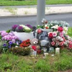 Fiori e ricordo in luogo di incidente stradale mortale con orsacchiotto commemorativo