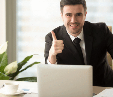 legal-design-6 Professionista studio legale sorridente con pollice alzato davanti laptop in ufficio moderno