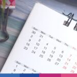 Calendario da tavolo con spirale metallica e date mesi, strumenti di pianificazione fiscale e organizzazione aziendale