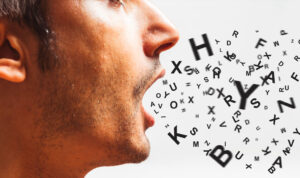 Uomo che parla con lettere e caratteri in uscita dalla bocca, simbolo di comunicazione verbale e linguaggio