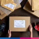 Imballaggio e spedizione di pacco con etichetta indirizzo su scrivania logistica ecommerce
