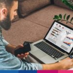 Uomo che analizza dati fiscali e fatturazione elettronica su laptop con grafici e tabelle