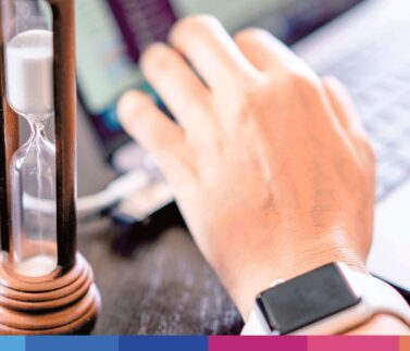 ts_magazine_11-1-17 Clessidra con sabbia e mano d'uomo con smartwatch su scrivania, simbolo di gestione del tempo in ambito legale e fiscale