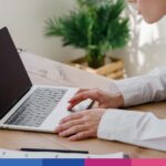 Professionista legale consulta laptop per dichiarazione redditi e adempimenti fiscali