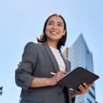 Donna professionista con tablet in ambiente urbano, simbolo di consulenza legale e fiscale moderna