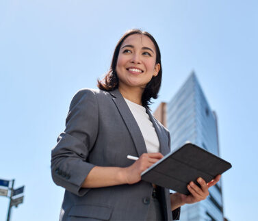 Donna professionista con tablet in ambiente urbano, simbolo di consulenza legale e fiscale moderna