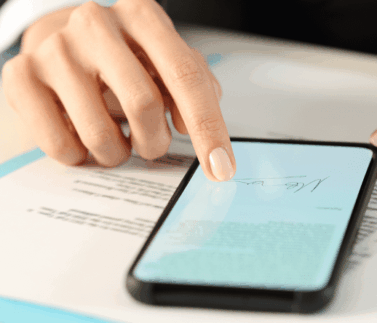 Mano tocca smartphone con documento fiscale su scrivania con fogli blu