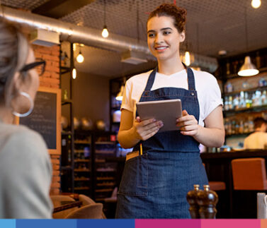 Cameriera con tablet prende ordine cliente al bancone del ristorante moderno