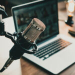 Studio podcast legale con microfono professionale e laptop per trasmissioni fiscali