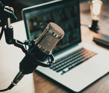 Studio podcast legale con microfono professionale e laptop per trasmissioni fiscali
