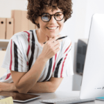 Professionista donna al computer che lavora su documentazione fiscale e amministrativa aziendale