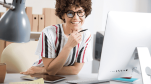 Consulente fiscale donna al computer che analizza documenti aziendali con tablet e penna