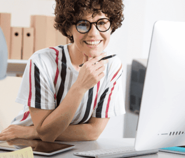 Donna consulente con occhiali al lavoro davanti a computer in ufficio moderno