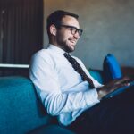 Professionista legale in ufficio moderno consulta documenti su laptop per analisi fiscale