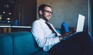 Professionista legale in ufficio moderno consulta documenti su laptop per analisi fiscale