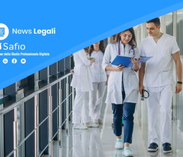 Team di medici specialisti in camice bianco consultano documentazione in corridoio ospedaliero