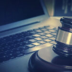 Martello giudiziale su tastiera di computer per processo penale e giustizia digitale