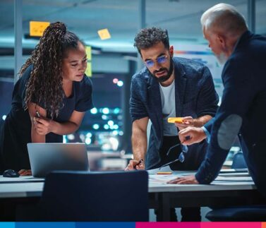 Tre professionisti discutono di strategia legale e fiscale davanti a laptop in ufficio moderno