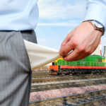 Professionista che tiene in mano documenti contrattuali con treno e infrastrutture industriali sullo sfondo