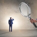 Uomo d'affari in abito esaminato al microscopio, simbolo dell'analisi legale del patto leonino e esclusione del socio