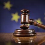Martello giudice davanti bandiera UE, simbolo giustizia europea e diritto comunitario aiuti di stato