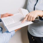 Due professionisti consultano documento legale durante riunione professionale