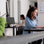 Impiegata comunale in ufficio pubblico al lavoro al computer in amministrazione